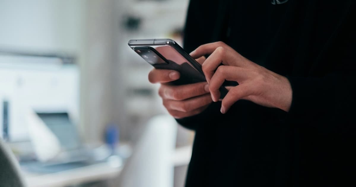 Persona escribiendo un mensaje en su celular, representando el chat con Meta AI en WhatsApp